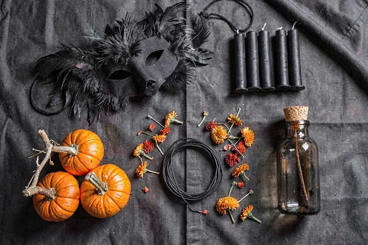 Halloween flat lay: mask, candles and pumpkins on dark linen — example output